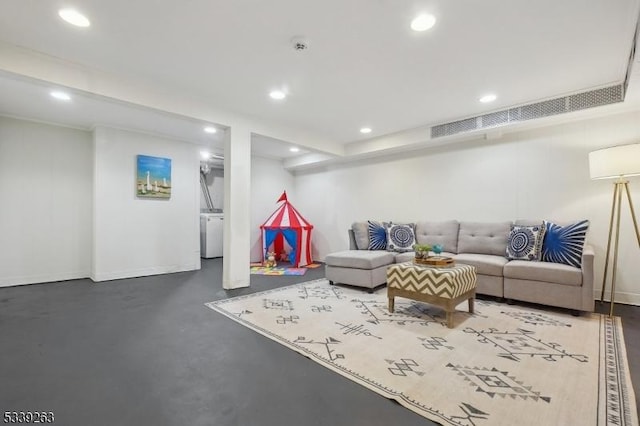 living room featuring finished concrete floors, baseboards, and recessed lighting