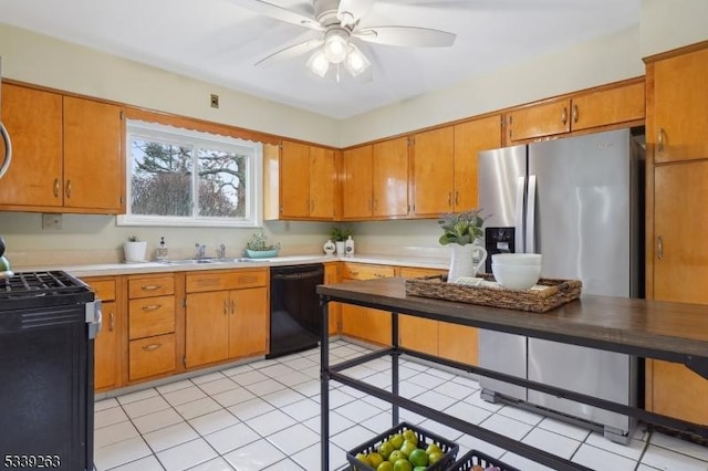 kitchen with black dishwasher, gas range oven, a sink, and brown cabinetry