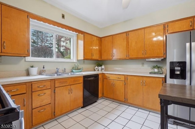 kitchen featuring brown cabinets, appliances with stainless steel finishes, light countertops, and a sink