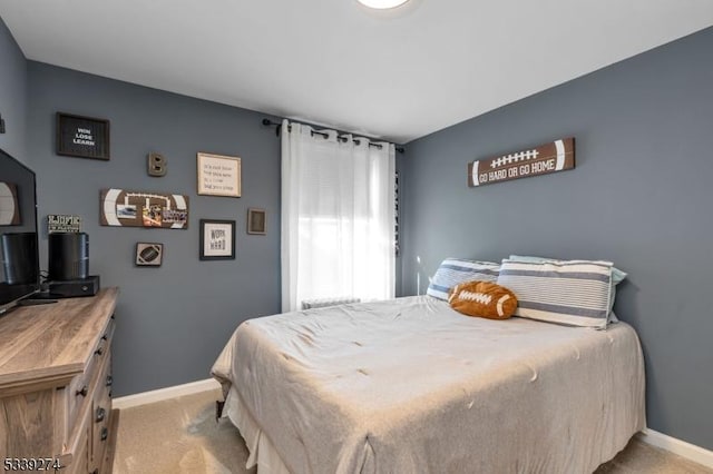 bedroom with light carpet and baseboards