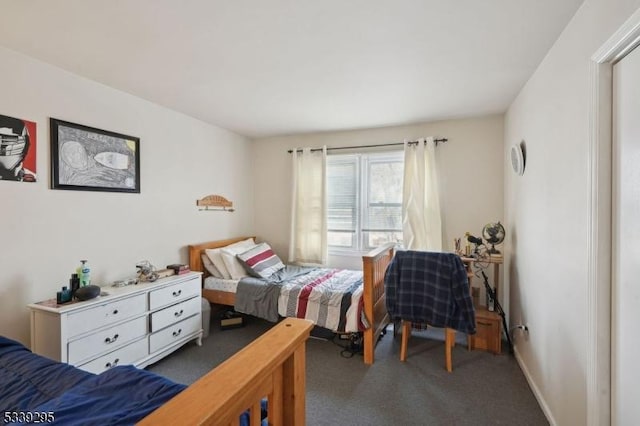 bedroom with dark carpet and baseboards