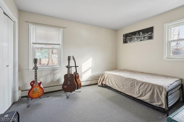 bedroom with carpet floors, baseboard heating, and a closet