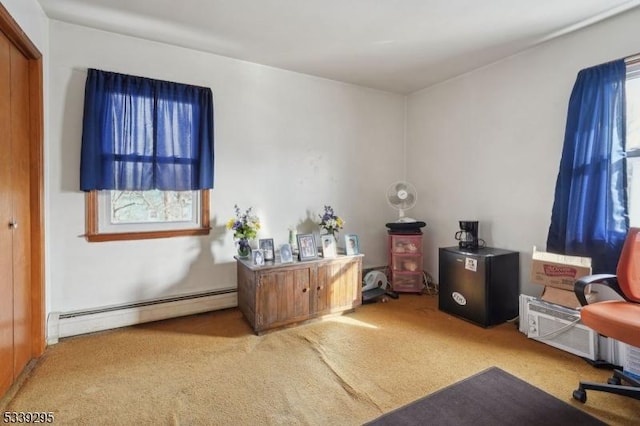 office space featuring a baseboard heating unit, light colored carpet, and a healthy amount of sunlight