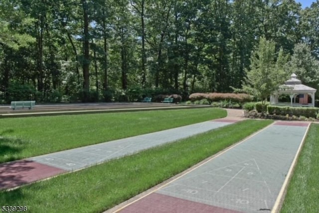 view of home's community with a lawn, a gazebo, and shuffleboard