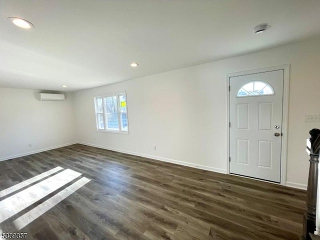 foyer featuring dark wood-style floors, recessed lighting, a wall mounted air conditioner, and baseboards