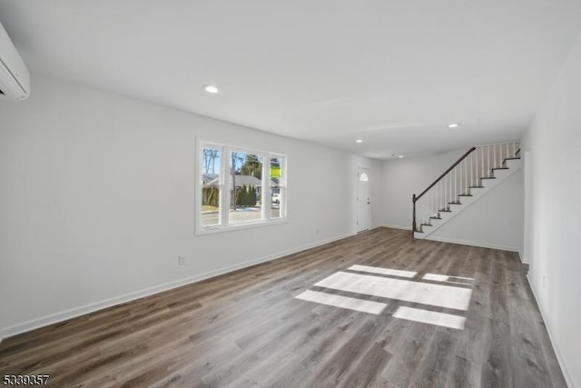 unfurnished living room with recessed lighting, stairway, baseboards, and wood finished floors