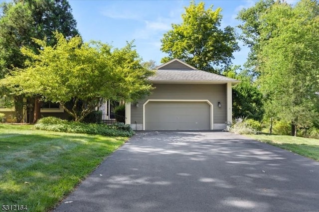 view of front of property featuring driveway, a garage, and a front yard