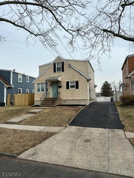 bungalow-style home with driveway and fence