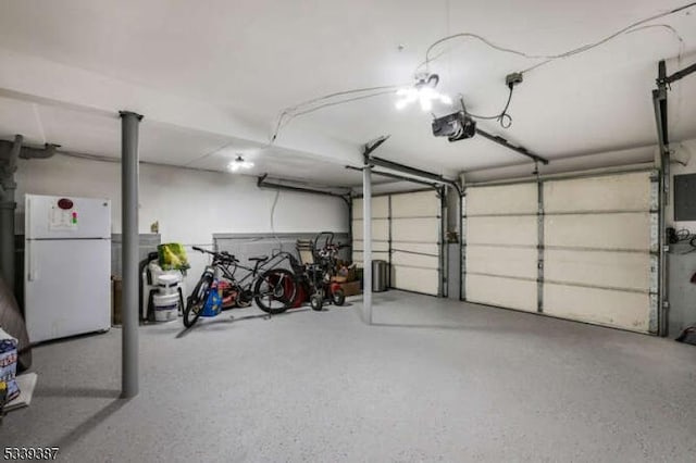 garage with a garage door opener and freestanding refrigerator