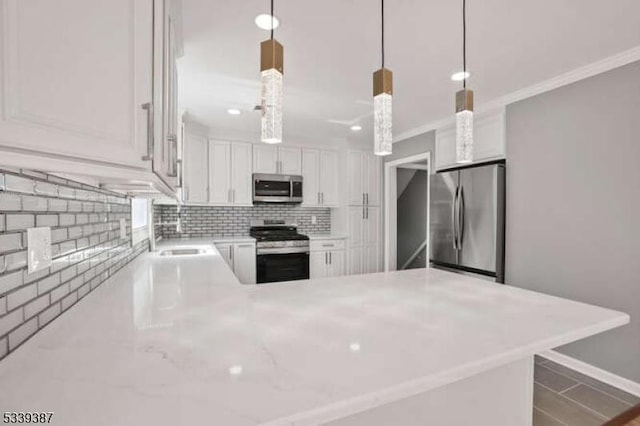 kitchen featuring stainless steel appliances, tasteful backsplash, white cabinetry, a sink, and a peninsula