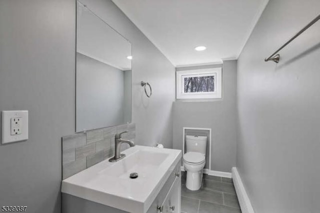 half bath featuring baseboards, toilet, tile patterned floors, baseboard heating, and vanity