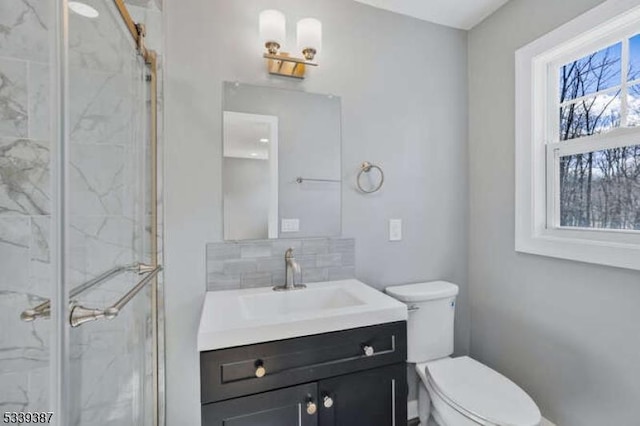 bathroom with tasteful backsplash, a marble finish shower, vanity, and toilet