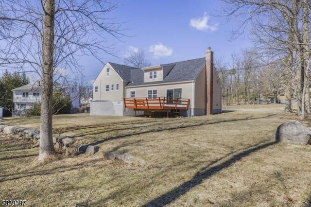 back of property with a chimney and a wooden deck