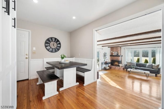 kitchen featuring dark countertops, a breakfast bar, open floor plan, wood finished floors, and a center island