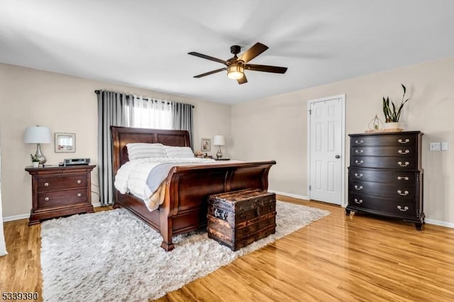 bedroom featuring a ceiling fan, light wood-style flooring, and baseboards