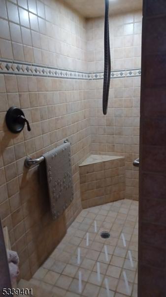 full bath with a tile shower and tile patterned floors