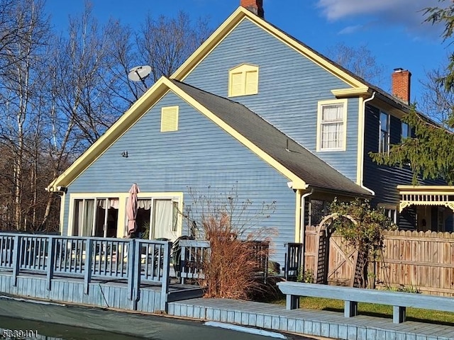 back of house featuring fence and a wooden deck