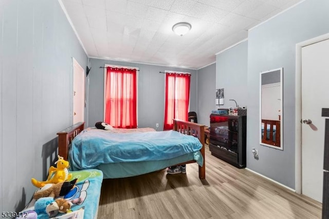 bedroom featuring crown molding and wood finished floors