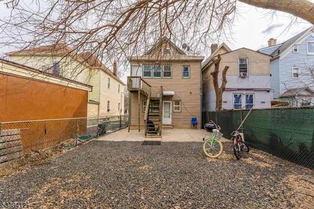 back of property featuring entry steps, a fenced backyard, and a patio