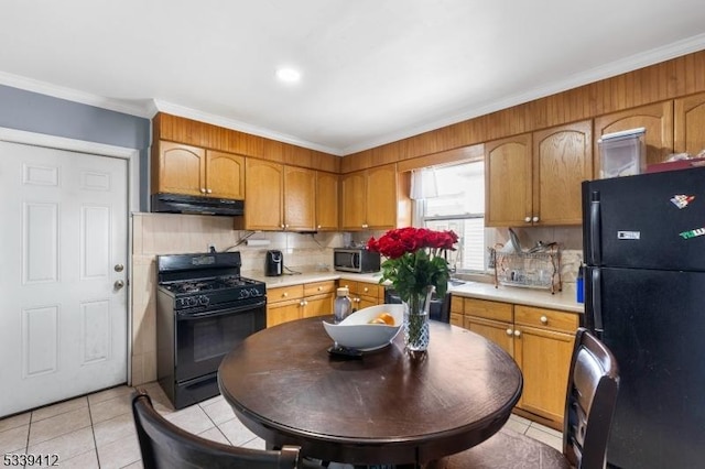 kitchen featuring decorative backsplash, under cabinet range hood, light countertops, black appliances, and light tile patterned flooring