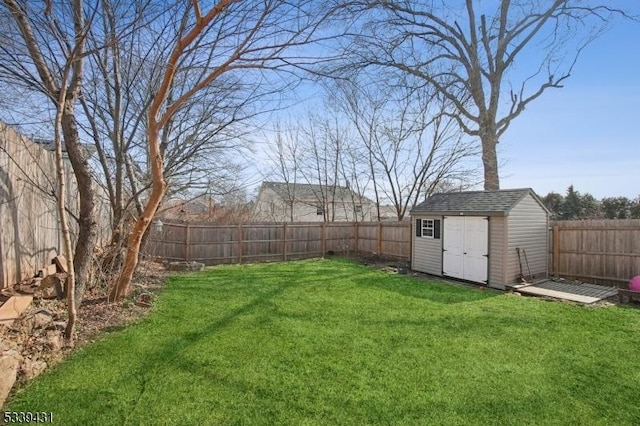 view of yard with a storage shed, a fenced backyard, and an outdoor structure