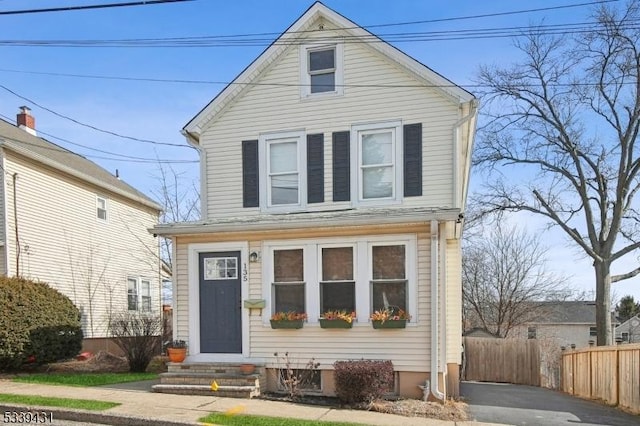 traditional-style house with entry steps and fence