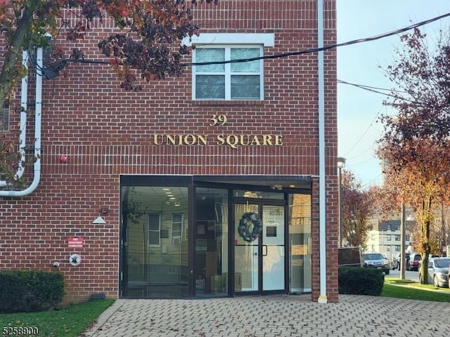 doorway to property featuring brick siding