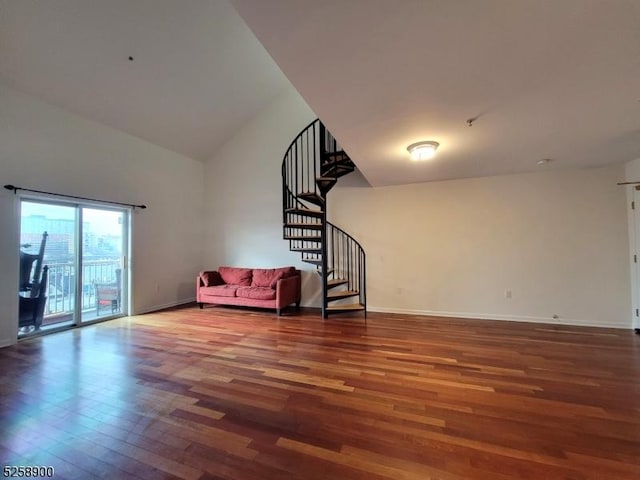 unfurnished living room featuring baseboards, stairs, high vaulted ceiling, and wood finished floors