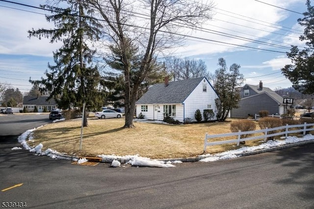 view of front facade featuring a front yard and fence