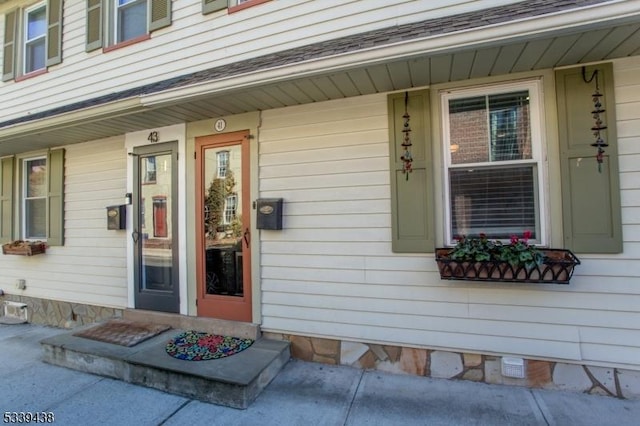 entrance to property with a shingled roof