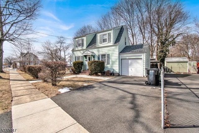 view of front of home featuring a garage, driveway, and a shingled roof