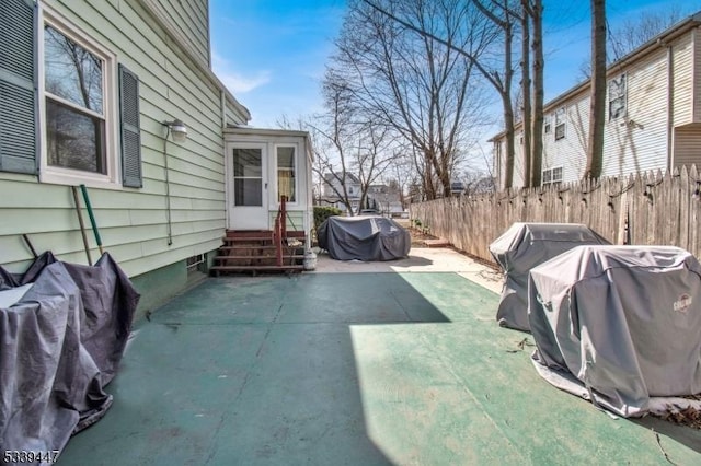 view of patio / terrace featuring entry steps, fence, and a grill