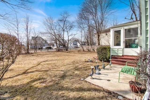 view of yard with entry steps, a patio area, fence, and a residential view