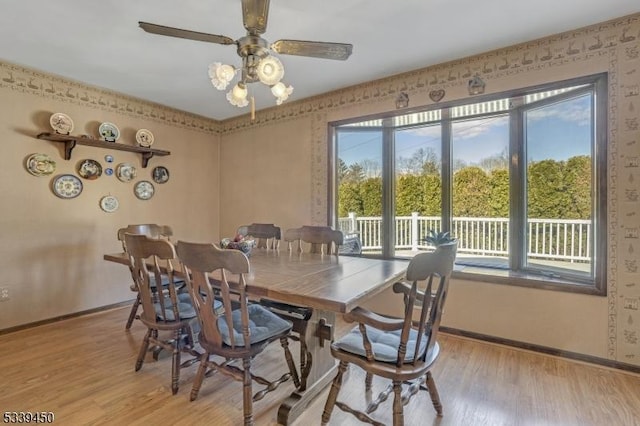 dining space with baseboards, light wood-style floors, and a ceiling fan