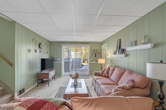 living area with stairway, a paneled ceiling, visible vents, and carpet floors