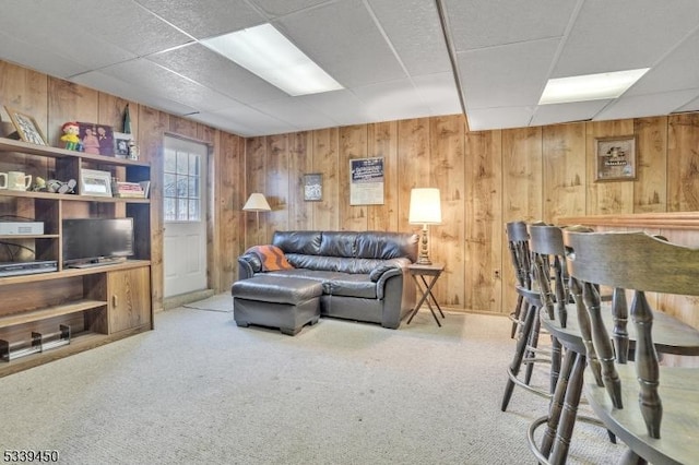 living area featuring carpet and wood walls