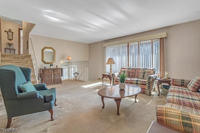 carpeted living area with stairs