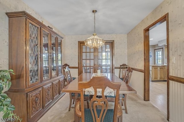 dining area featuring wallpapered walls, plenty of natural light, and wainscoting