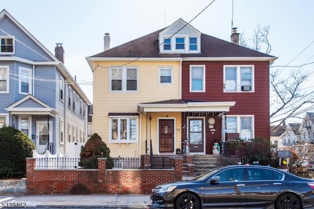 view of front facade with a chimney and a fenced front yard