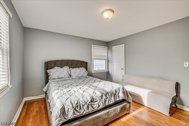 bedroom with baseboards and wood finished floors