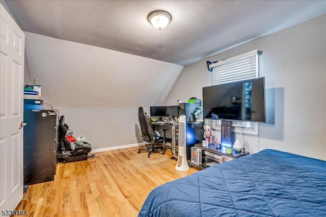 bedroom featuring vaulted ceiling, wood finished floors, and baseboards