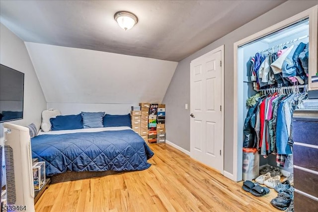 bedroom featuring vaulted ceiling, baseboards, and wood finished floors