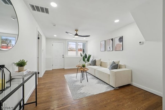 living area featuring baseboards, visible vents, wood finished floors, and recessed lighting