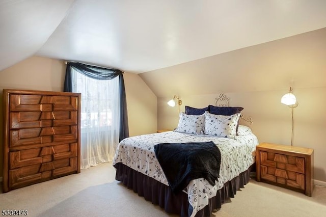 bedroom featuring lofted ceiling and light carpet