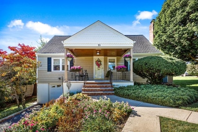 view of front of home featuring covered porch, a shingled roof, a chimney, and a garage