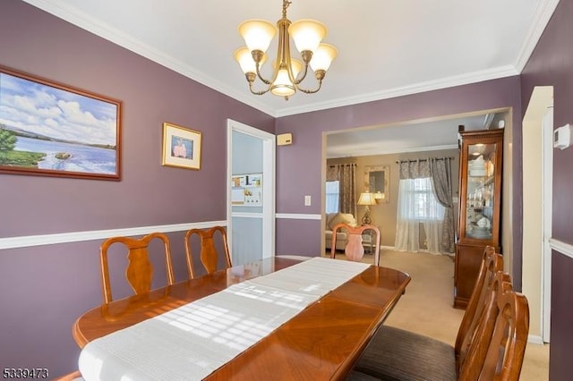 dining space with crown molding, a notable chandelier, and light colored carpet