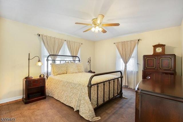 bedroom featuring a ceiling fan and baseboards