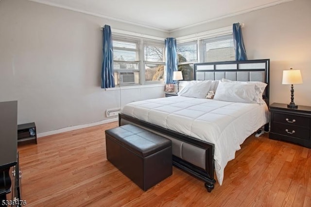 bedroom featuring cooling unit, baseboards, and wood finished floors