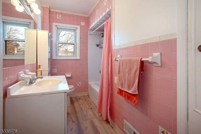 bathroom featuring a wealth of natural light, tile walls, vanity, and wood finished floors