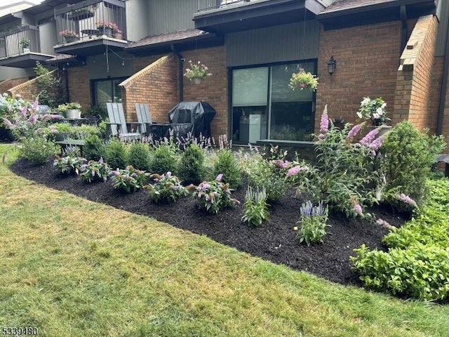 view of side of property with a yard and brick siding